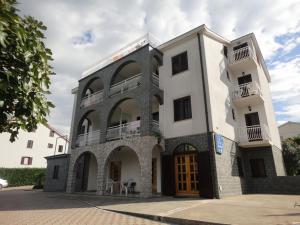 un grande edificio bianco con balconi in cima di Apartments Ivo a Porat