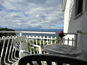un tavolo e due sedie su un balcone con vista sull'oceano di Apartments Ivo a Porat