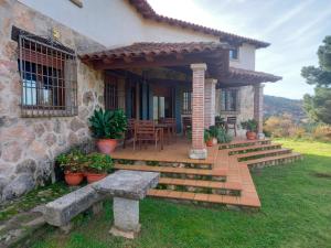 Casa con porche de madera con mesa en La Cirujana de Gredos, en San Esteban del Valle