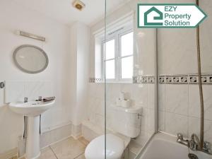 a bathroom with a toilet and a sink and a shower at Stylish 2 bed Apt - Free Parking in Thamesmead