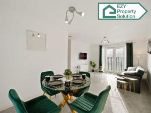 a living room with a table and green chairs at Stylish 2 bed Apt - Free Parking in Thamesmead