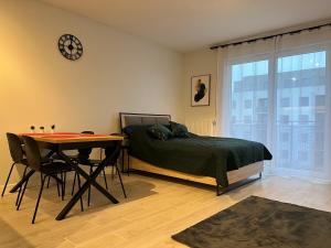 sypialnia z łóżkiem, stołem i zegarem w obiekcie Harmonia Apartments w Szczecinie