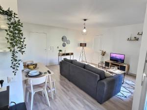 a living room with a couch and a table at L'ÉLÉGANT - ED IZISMA in Guyancourt