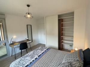 1 dormitorio con cama, escritorio y espejo en L'ÉLÉGANT - ED IZISMA en Guyancourt