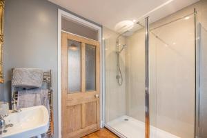 a bathroom with a shower and a sink at The Old Shop in Leiston