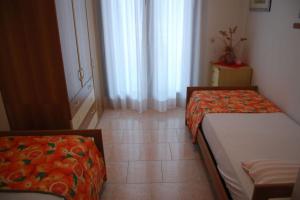 a small room with two beds and a window at Comfy apartment with balcony and ac in Bibione