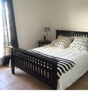 sypialnia z czarno-białym łóżkiem i oknem w obiekcie Marina Aigues Mortes 75m2 w mieście Aigues-Mortes