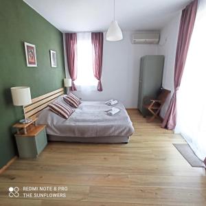 a bedroom with a bed and a large window at Guest House Sunflowers in Pomorie
