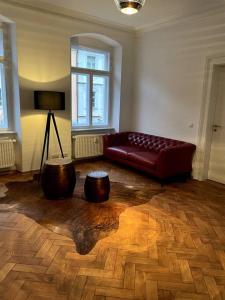 ein Wohnzimmer mit einem roten Sofa und zwei Holzscheiten in der Unterkunft Penthouse Wohnung in 1A City-Lage in Bamberg in Bamberg