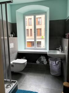 a bathroom with a window and a toilet and a sink at Penthouse Wohnung in 1A City-Lage in Bamberg in Bamberg