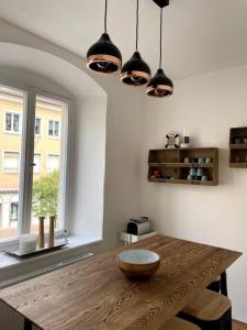 a dining room with a wooden table and lights at Penthouse Wohnung in 1A City-Lage in Bamberg in Bamberg