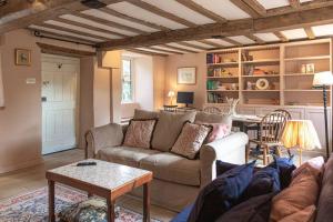 a living room with a couch and a table at Charming Country Cottage Near Nailsworth in Box