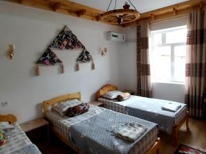 a room with two beds and a window at NAZIRA Boutique Hotel & Terrace in Khiva +133 photos