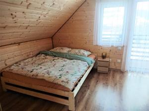 a bedroom with a bed in a wooden cabin at Domek Na Starej Cegielni in Baligród