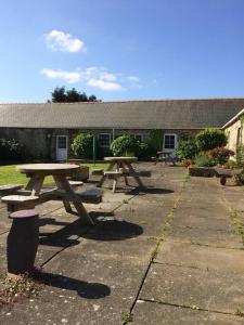 a group of picnic tables in front of a building at 5 Glantraeth Farm Cottage in Bodorgan