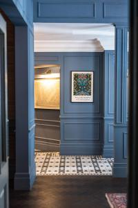 a hallway with blue walls and a painting on the wall at The Tophams Hotel in London