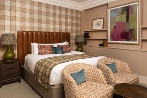 a bedroom with a bed and a table and chairs at The Tophams Hotel in London