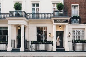 a woman standing in front of a white building at The Tophams Hotel in London