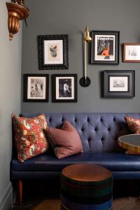 a blue couch in a living room with pictures on the wall at The Tophams Hotel in London