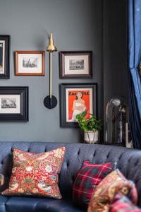 a blue couch in a living room with pictures on the wall at The Tophams Hotel in London