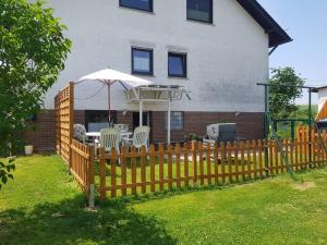 a wooden fence with an umbrella in front of a house at Ferienwohnung BeLa, Nähe Nürburgring in Luxem