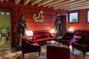 威尼斯Excess Venice Boutique Hotel & Private Spa - Adults Only的大厅,有一面红色的墙,上面有2个男人的雕像