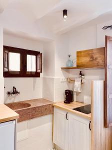 a kitchen with white cabinets and a sink at Ca tia Teresa in Planes