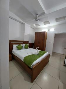 a bedroom with a large bed with green sheets at Sharp Suites in Ernakulam