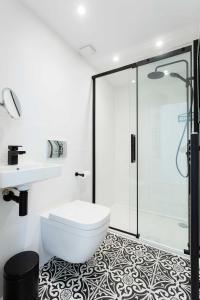 a bathroom with a shower and a toilet and a sink at Veeve - Richmond on Canvas in Richmond upon Thames