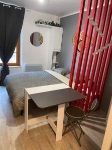 a bedroom with a bed and a table and a chair at Appart hôtel Toucy in Toucy