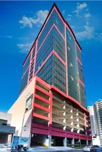 a tall building with red and green windows at Diva Hotel in Manama