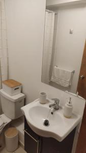 Baño blanco con lavabo y aseo en Departamento full equipado, en La Serena