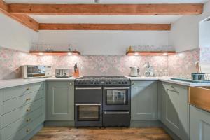 a kitchen with blue cabinets and a stove at Cosy Bake Cottage, Great Location in Looe, Cornwall in Looe