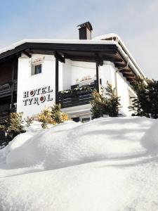 a building with a pile of snow in front of it at Hotel Tyrol in Selva di Val Gardena