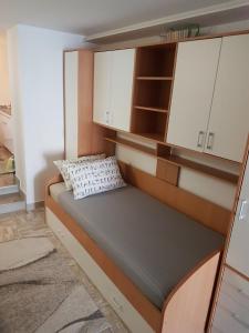 Ce lit se trouve dans un dortoir doté de placards blancs. dans l'établissement Apartmani Most, à Trebinje