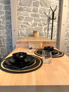 un tavolo in legno con piatti neri e bicchieri di Ciney - Le nid du Clocher a Ciney