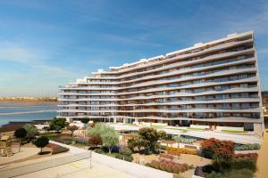 a large apartment building next to a body of water at Los Flamencos - Playa Paraíso - Calle Bomilcar in Cartagena
