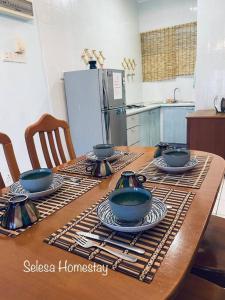 a wooden table with bowls and plates on it at OCEAN ESCAPE@Selesa Hillhomes, Bukit Tinggi Pahang in Bentong