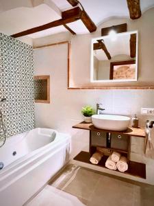 a bathroom with a tub and a sink and a mirror at Ca tia Teresa in Planes