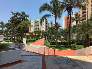 un parque en una ciudad con palmeras y edificios en Riviera Modulo 6 - 150 metros da praia - ATENÇÃO Piscina em reforma, en Riviera de São Lourenço
