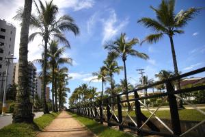 um caminho com palmeiras e uma cerca em Riviera Modulo 6 - 150 metros da praia - ATENÇÃO Piscina em reforma em Riviera de São Lourenço