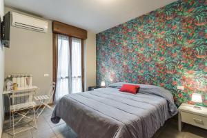 1 dormitorio con 1 cama grande y pared colorida en Residenza Il Fiore, en Bérgamo