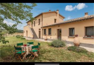 a table and chairs in front of a house at Casettone di Torre Venturini in Civitella dʼAgliano