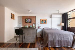 1 dormitorio con 1 cama y 1 silla en Loft do Serjoca, en São Paulo