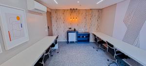 una clase con escritorios y sillas en una habitación en Blend Smart Style Estúdios Luxuosos e Decorados, en Goiânia