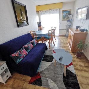 カネ・アン・ルシヨンにあるAppartement vue Mer et Port Canet en Roussillonのリビングルーム(青いソファ、テーブル付)