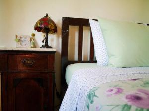 een slaapkamer met een bed, een dressoir en een lamp bij Maria's guesthouse Volos in Volos