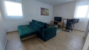 een woonkamer met een groene bank en een bureau bij Sumski san 3 in Divčibare