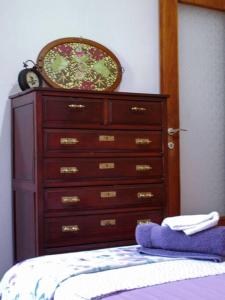 a bedroom with a dresser and a bed with a purple blanket at Maria's guesthouse Volos in Volos