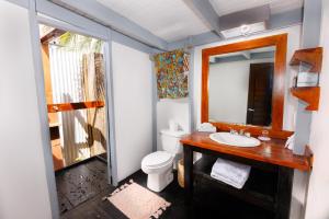 ein Badezimmer mit einem WC, einem Waschbecken und einem Spiegel in der Unterkunft Conch Beach Cabins 